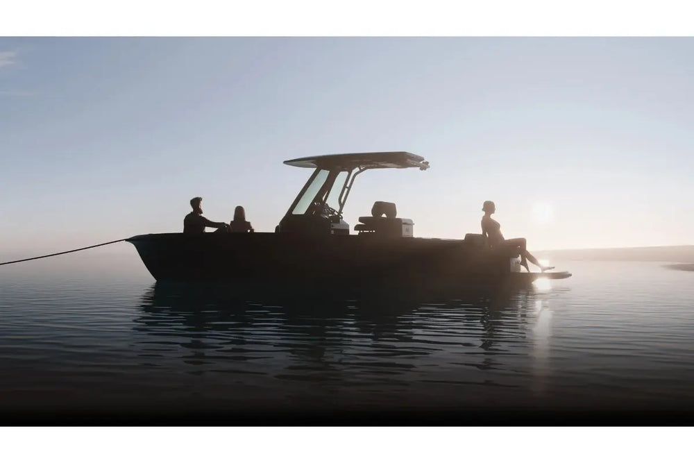 Arc Coast Electric Boat Silhouette on water with people on board during sunset.
