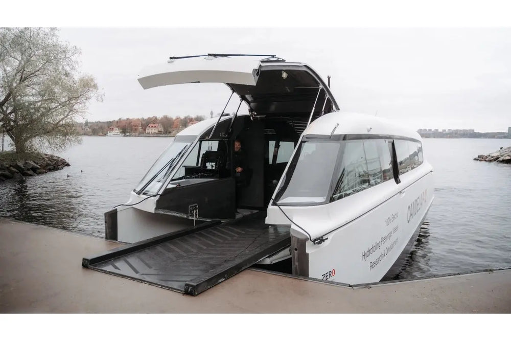 Candela P-12 White amphibious Ferry with open doors on a dock by water