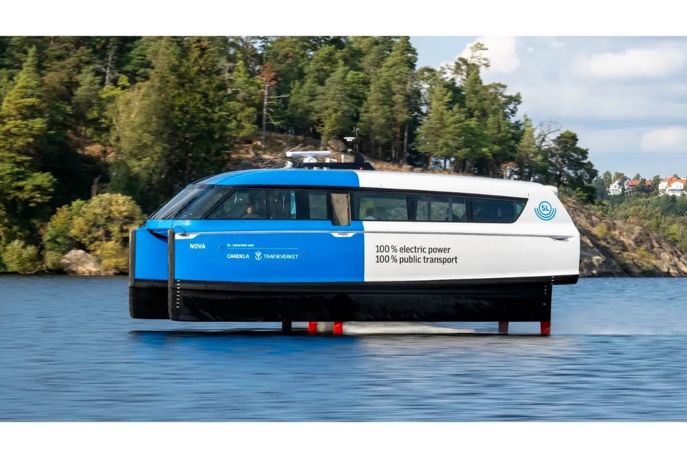 Candela P-12 Blue and white electric ferry on a lake with trees and buildings in the background