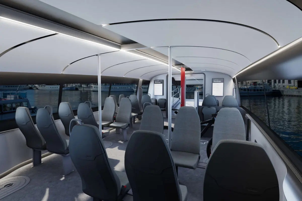 Candela P-12 Shuttle Electric Ferry Interior with gray seats and large windows showing water and boats outside.
