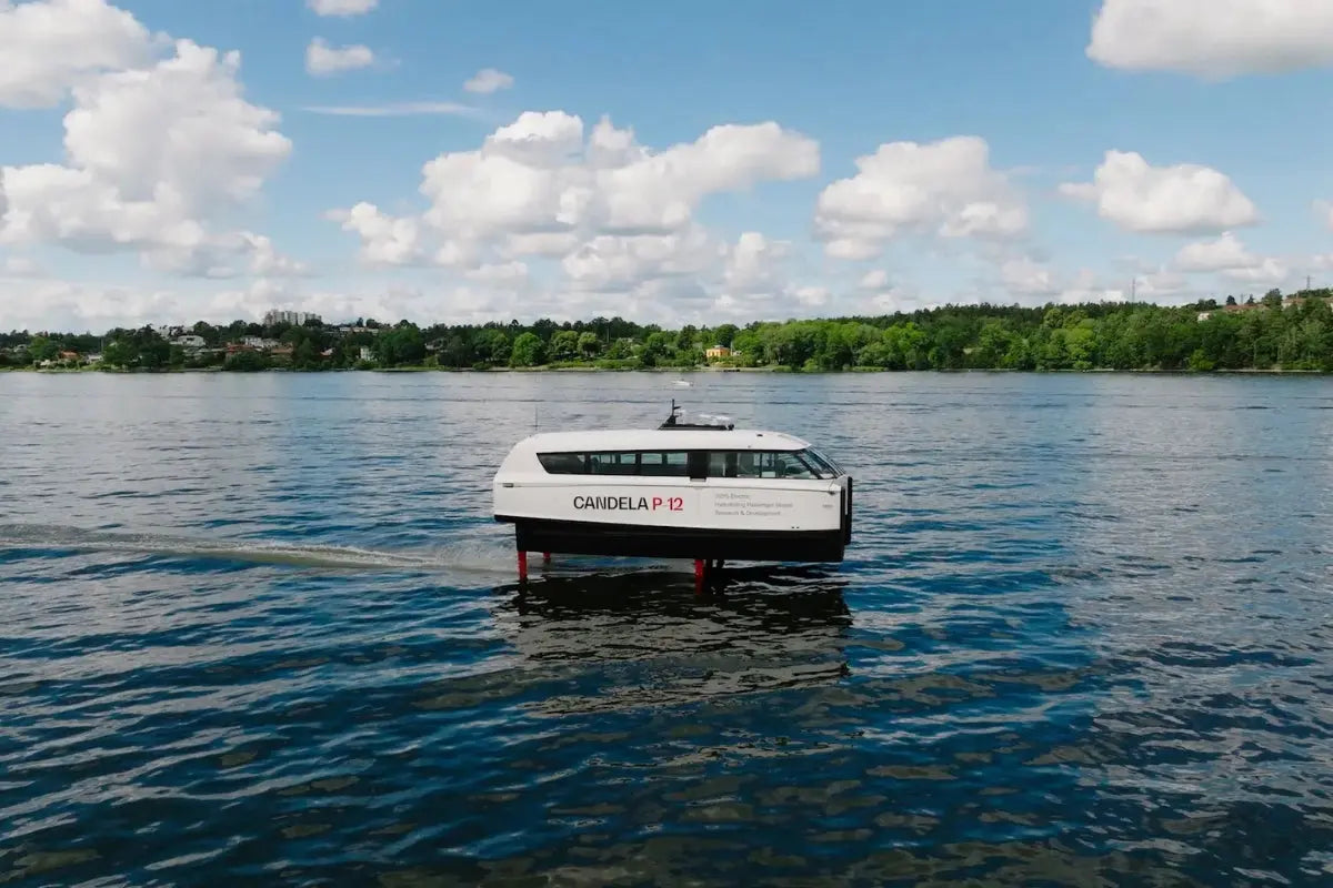 Candela P-12 White and black vehicle on water with  branding, blue sky and clouds in background