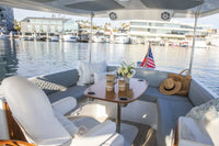 Duffy Balboa 20 Electric Boat Yacht interior with seating area, table, and decor on a waterfront.