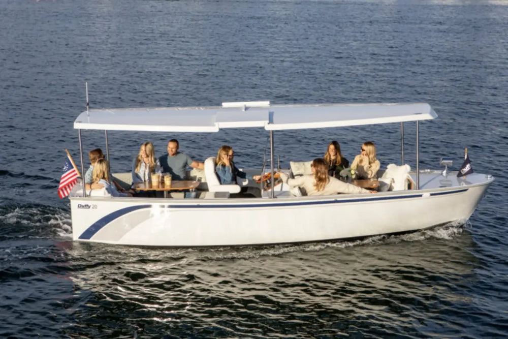 Group of people on a Duffy Balboa 20 Electric Boat in the water with an American flag.