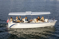 Group of people on a Duffy Balboa 20 Electric Boat in the water with an American flag.