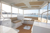 Duffy Balboa 20 Electric Boat Interior of a yacht with seating area and table, overlooking water.