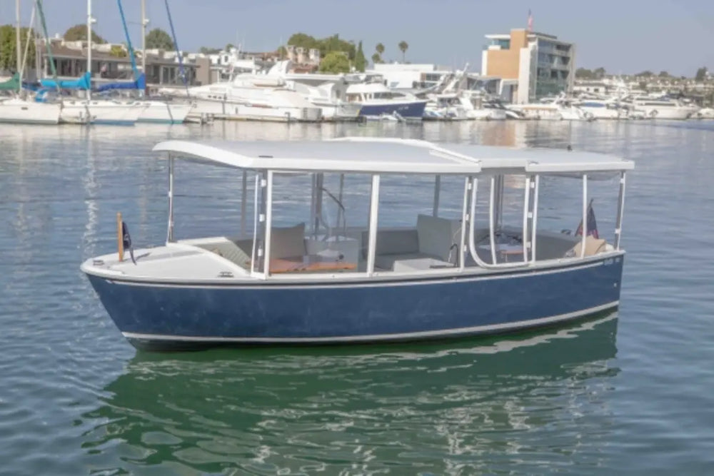 Duffy Balboa 20 Blue and white boat on a calm body of water with buildings in the background