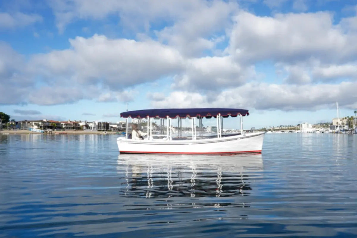 Duffy Bay Island 22 Electric Boat on calm water with a blue sky and clouds in the background