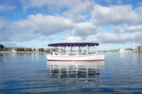 Duffy Bay Island 22 Electric Boat on calm water with a blue sky and clouds in the background