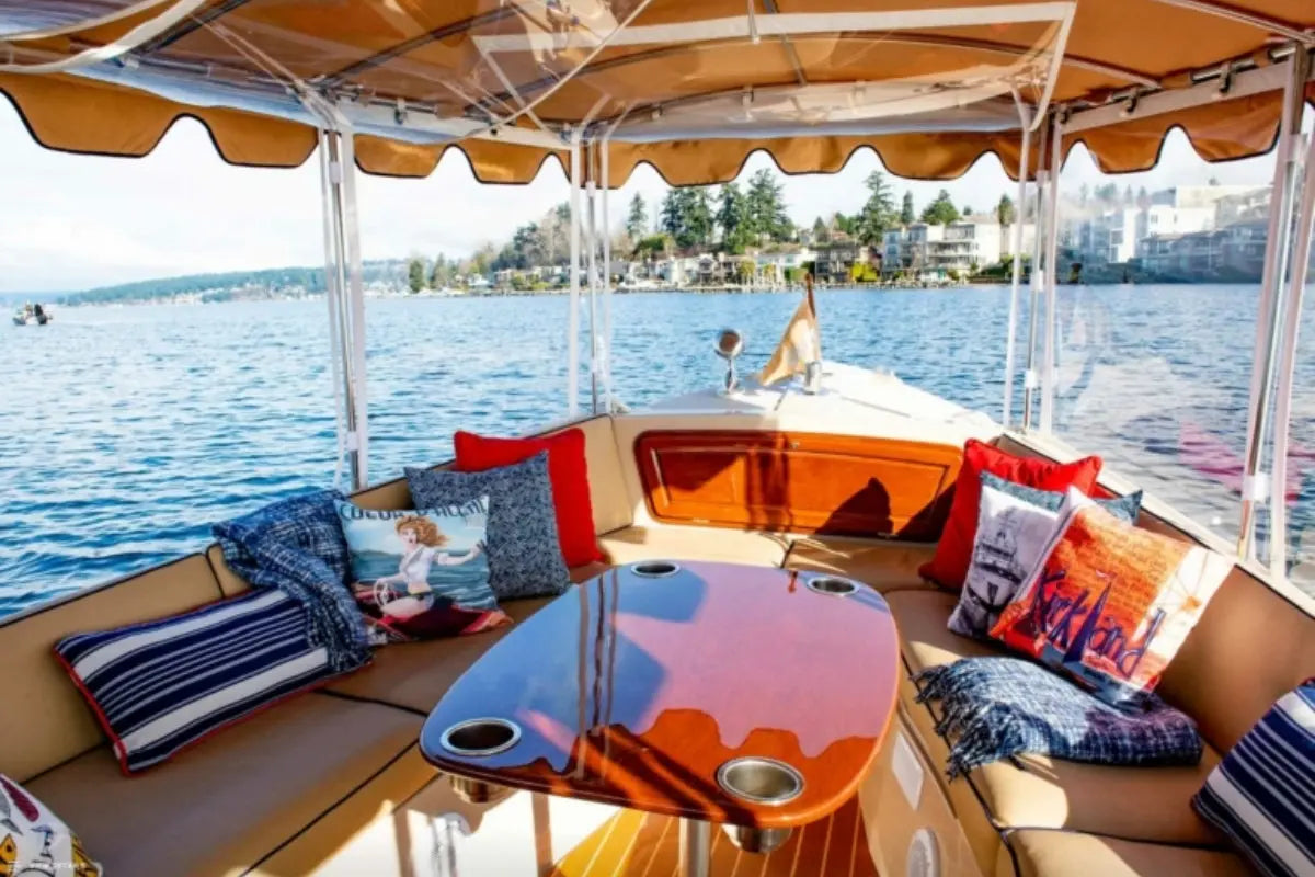 Interior of a Duffy Bay Island 22 Electric Boat with cushions and a table on a body of water