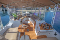 Interior of a luxurious Duffy Bay Island 22 Electric Boat with wooden floor, seating area, and steering wheel.