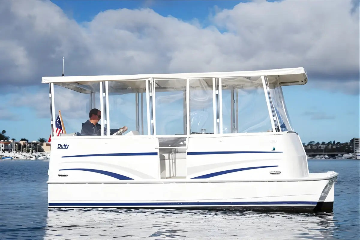 Duffy Cat 16 Electric Boat with blue stripes on a body of water under a cloudy sky