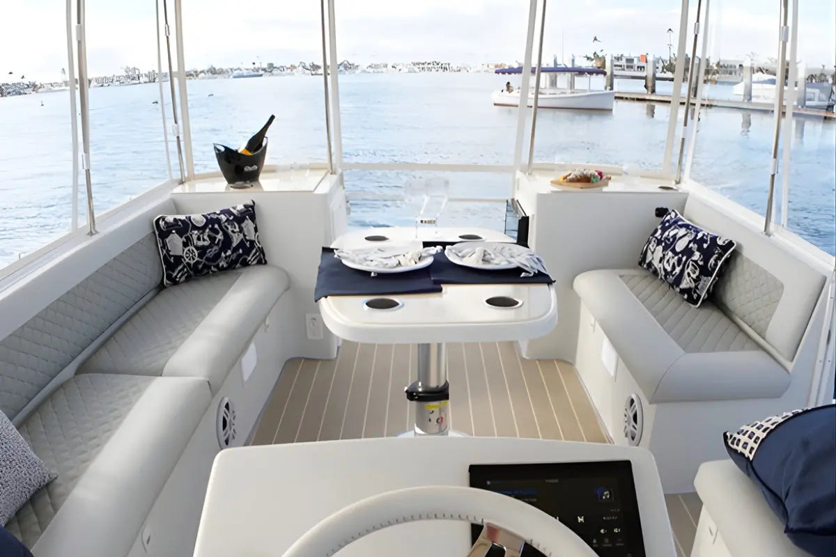 Interior of a Duffy Cat 16 Electric Boat with seating area, table, and view of water