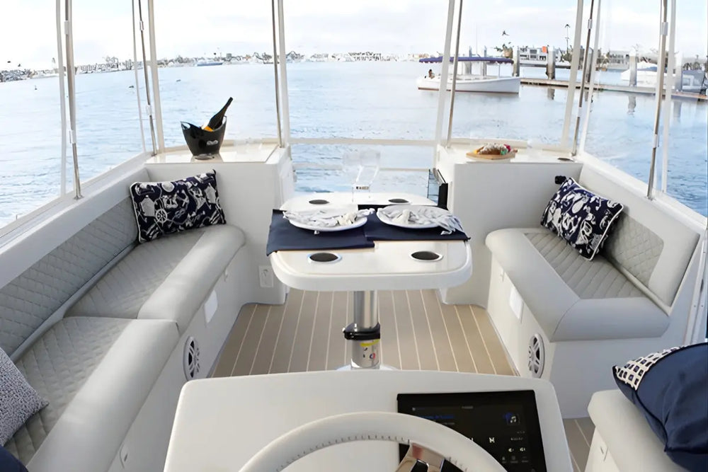 Interior of a Duffy Cat 16 Electric Boat with seating area, table, and view of water