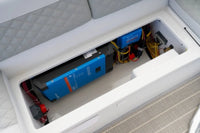 Electrical panel with blue battery and wiring inside a Duffy Cat 16 Electric Boat.