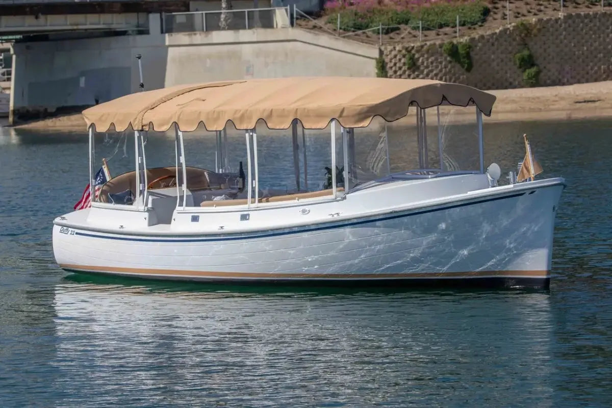 Duffy Cuddy Cabin 22 Electric Boat with a canopy on a body of water