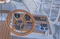 Wooden steering wheel and dashboard of Duffy Snug Harbor 18 Electric Boat with visible brand name 'Duffy'.
