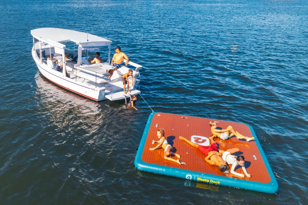 People on a Duffy Sun Cruiser 23 Electric Boat with a floating platform in the water