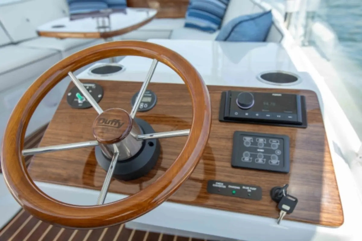 Wooden steering wheel on Duffy Sun Cruiser 23 Electric Boat with control panel in the background