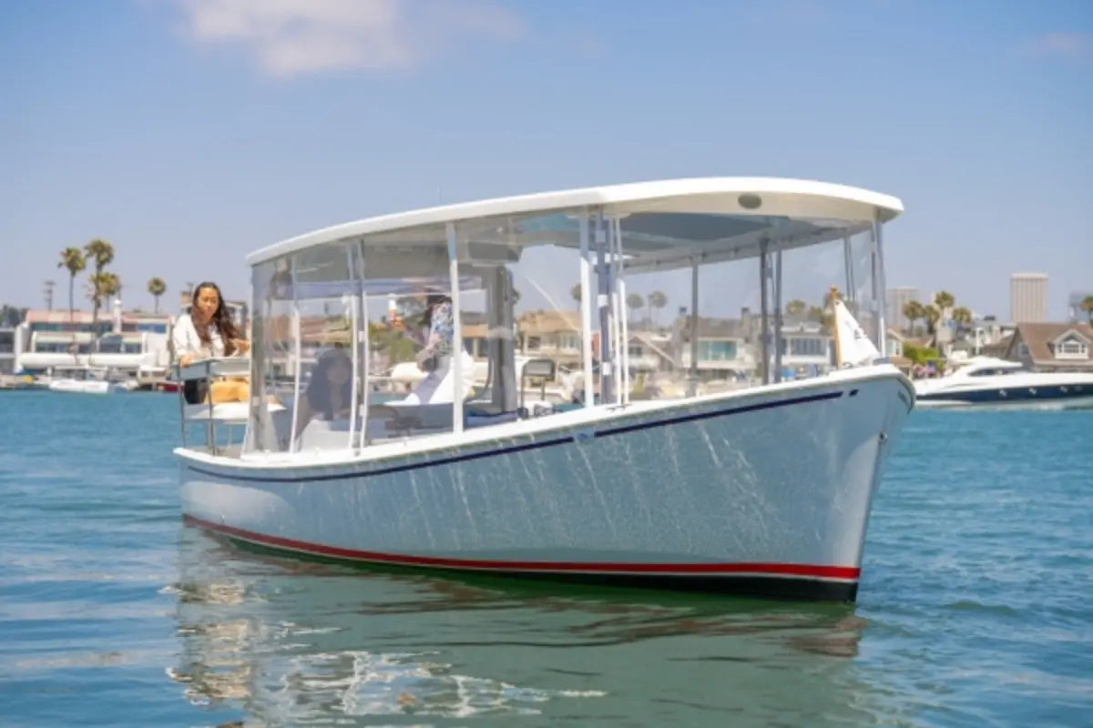 Duffy Sun Cruiser 23 Electric Boat with a canopy on a body of water with a clear sky.