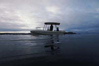 Elvene Amber Solar Electric Boat on water with a cloudy sky