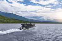 Flux Flagship Discover Electric Boat traveling on a lake with mountains in the background
