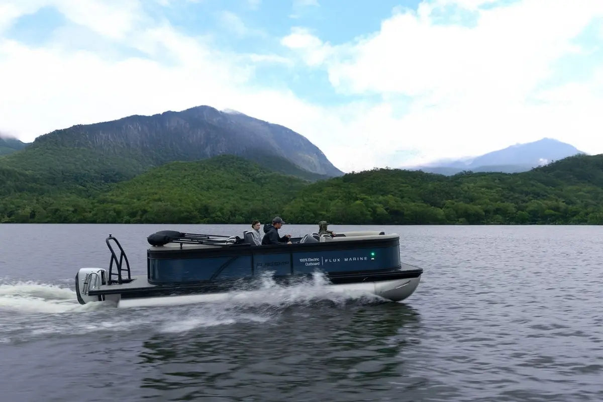 Flux Flagship Discover Electric Boat on a lake with mountains in the background