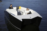 Two people in a small Flux GFX Stealth Electric Catamaran Boat on calm water