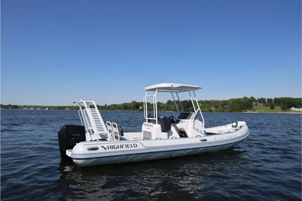 White Highfield Flux Highfield Sport 660 Electric Boat on a body of water with a clear blue sky.