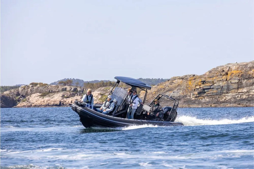Flux Highfield Sport 660 Electric Boat with people on a body of water near rocky cliffs