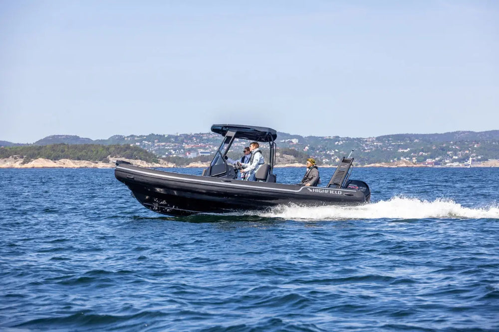Flux Highfield Sport 660 Electric Boat with people on a body of water, likely a lake or sea, with a scenic background.