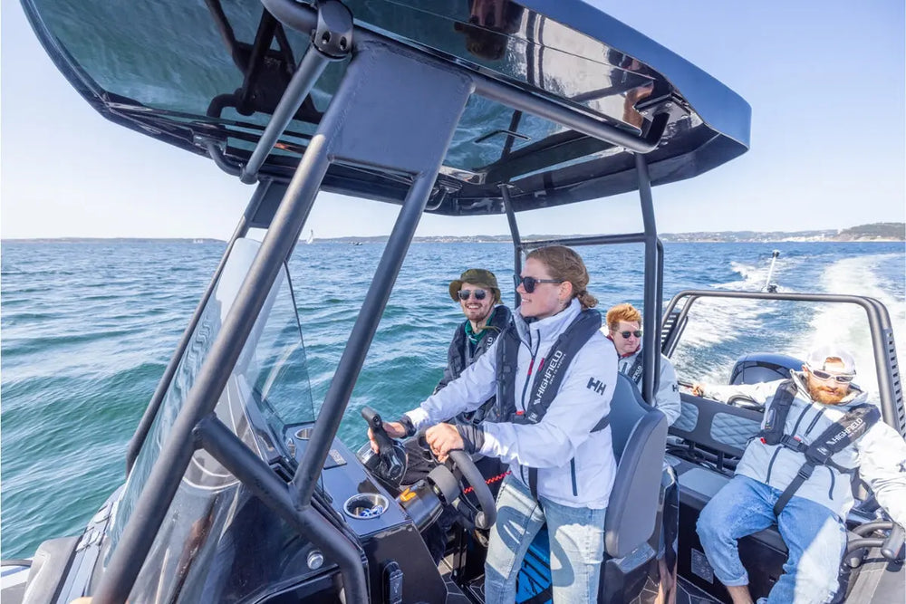 People on Flux Highfield Sport 660 Electric Boat in the water with a clear sky