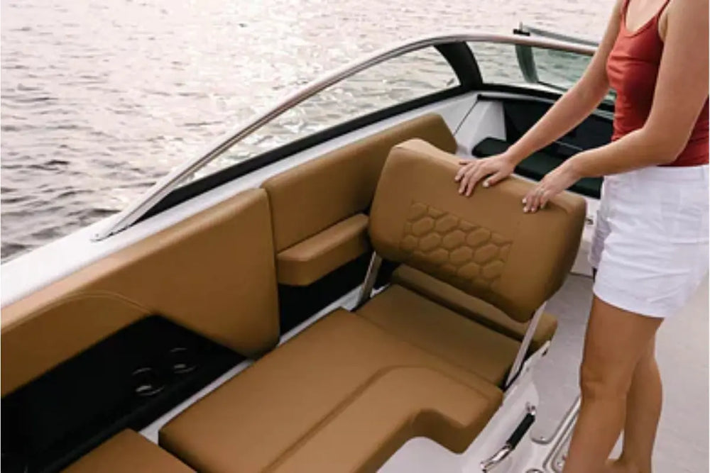 Person adjusting a brown seat on Four Winns H2e Electric Boat with water in the background