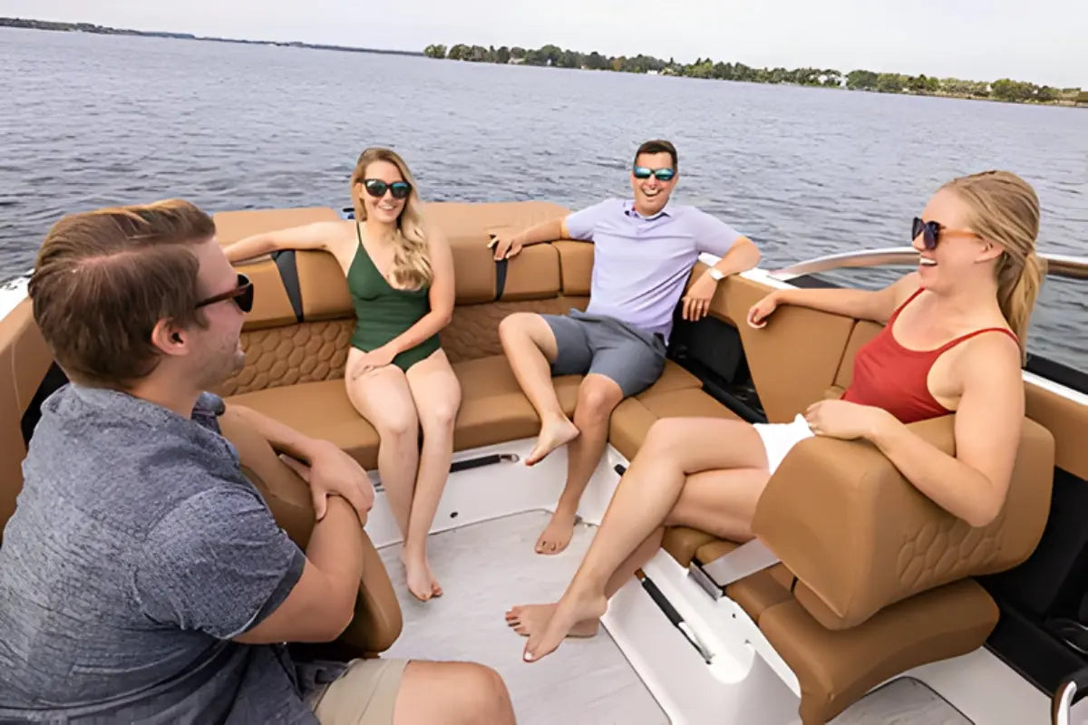 Four people sitting on Four Winns H2e Electric Boat deck with a lake in the background
