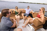 Four people sitting on Four Winns H2e Electric Boat deck with a lake in the background