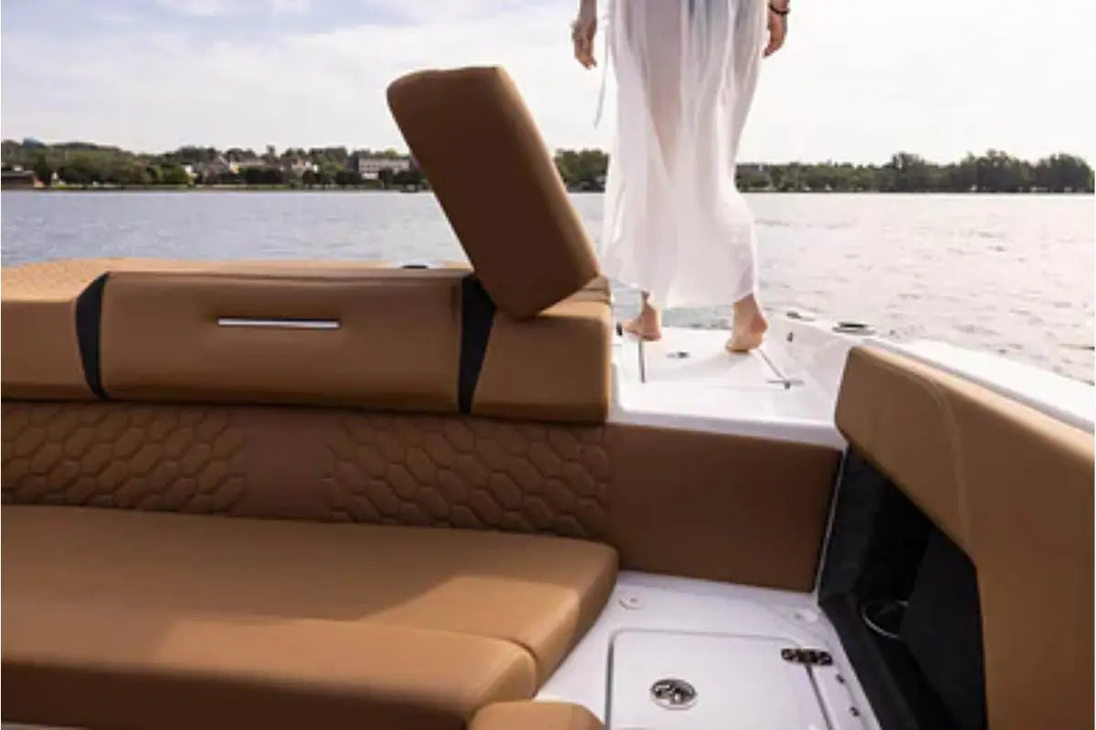 Brown leather interior of Four Winns H2e Electric Boat with a person in white pants standing on the deck.
