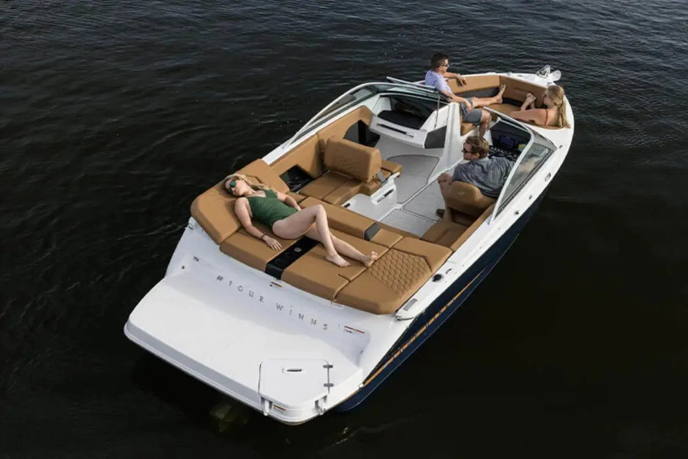Four Winns H2e Electric Boat on water with people inside, featuring a white exterior and brown interior.