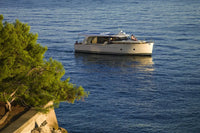 Greenline 40 Electric Yacht on a calm blue sea with green trees in the foreground