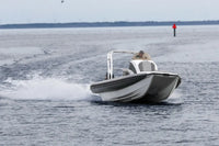 Hyfoil 22 Electric Boat speeding across a body of water with a clear sky.
