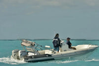 Two people on Hyfoil 22 Electric Boat in clear blue water with a Honda outboard motor.