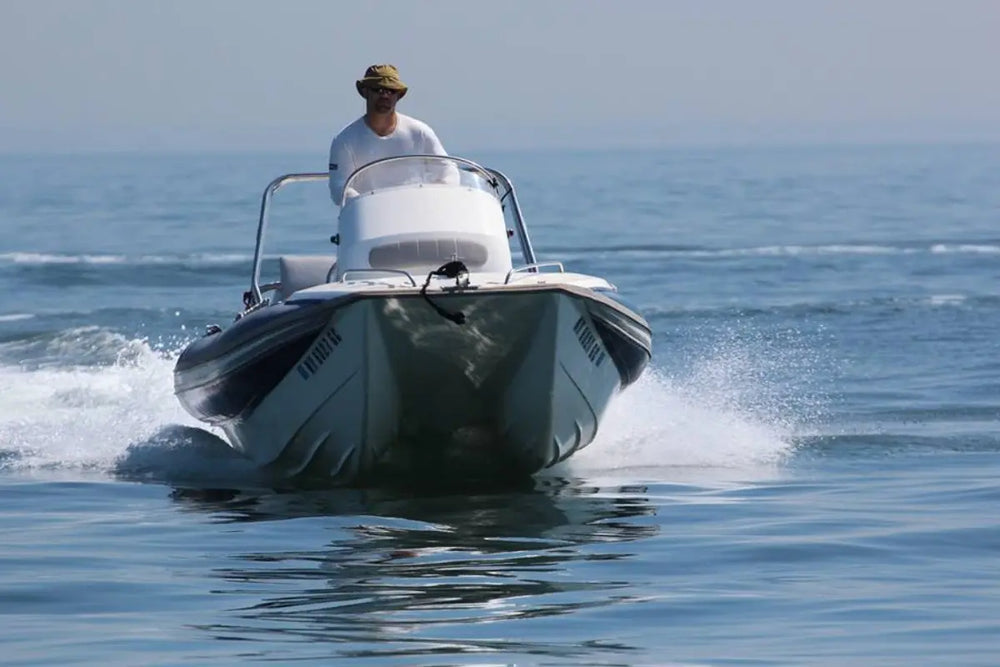 Person driving Hyfoil 22 Electric Boat on calm water with a clear sky