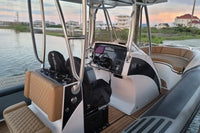 Hyfoil 28 Electric Boat interior with dashboard and seating area, water and buildings in the background