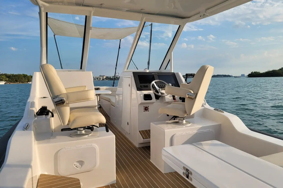 Interior of Hyfoil 32 Electric Boat with white seats and dashboard on a body of water.