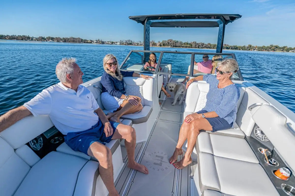 Group of people on an Ingenity 23e Electric Boat with a dog, enjoying a sunny day on the water.