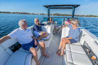 Group of people on an Ingenity 23e Electric Boat with a dog, enjoying a sunny day on the water.