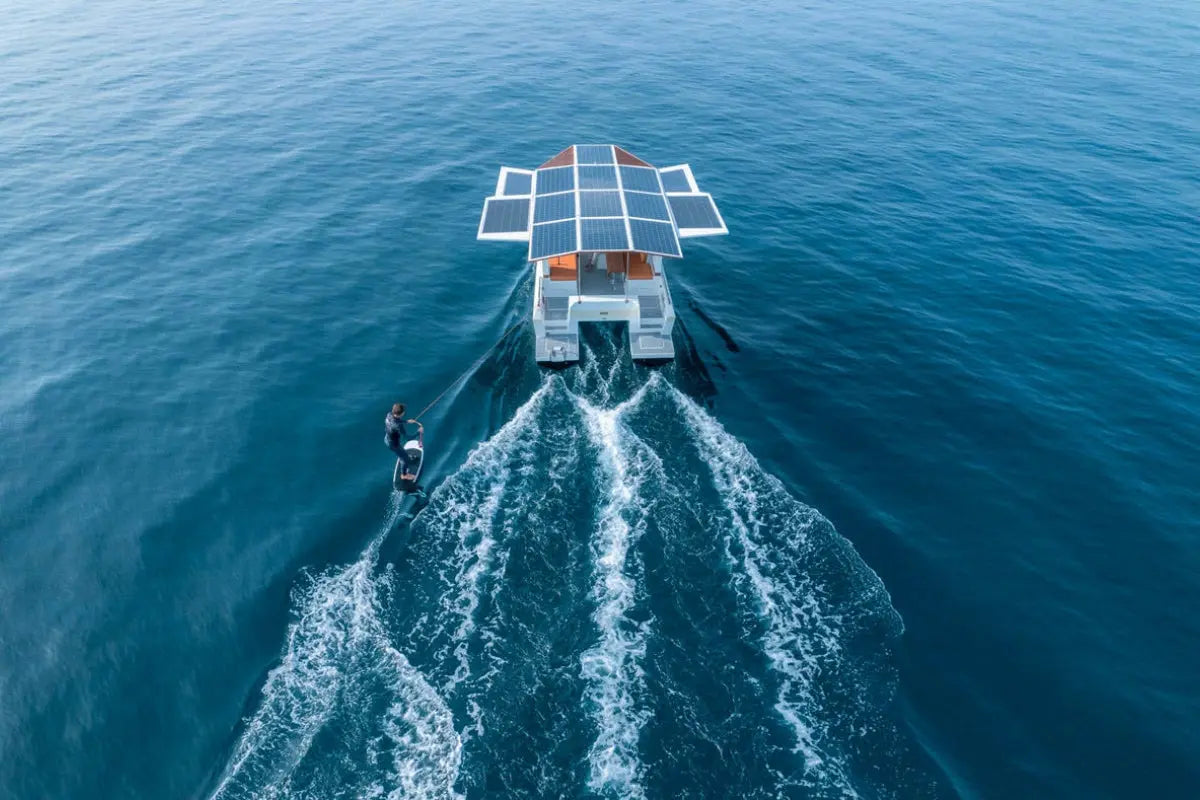 Solar-powered Millikan M9 Electric Boat on a body of water with a person in the foreground.