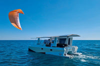 Millikan M9 Electric Boat catamaran with an orange sail on a blue ocean under clear skies