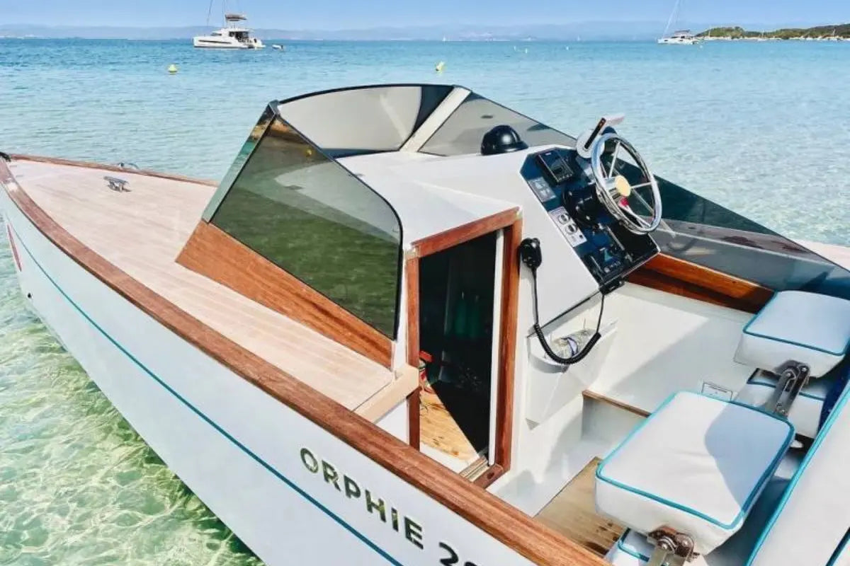 Nova Luxe Orphie 29 Electric Boat with wooden accents on a clear blue water background