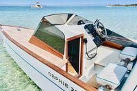 Nova Luxe Orphie 29 Electric Boat with wooden accents on a clear blue water background