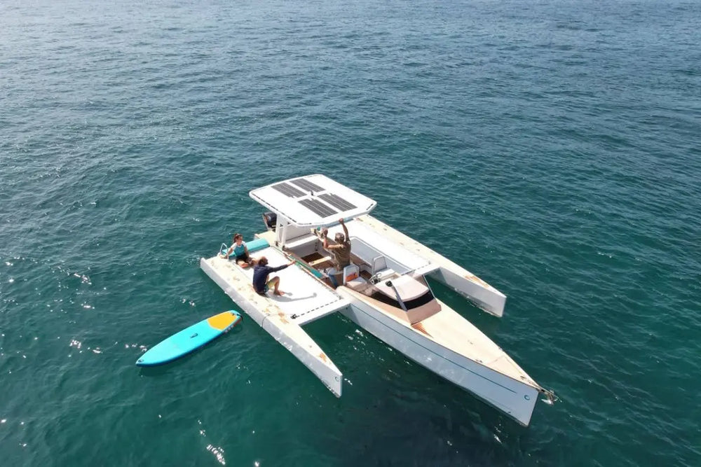 Nova Luxe Orphie 29 Electric Boat on the water with a kayak nearby