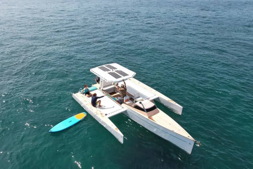 Nova Luxe Orphie 29 Electric Boat on the water with a kayak nearby